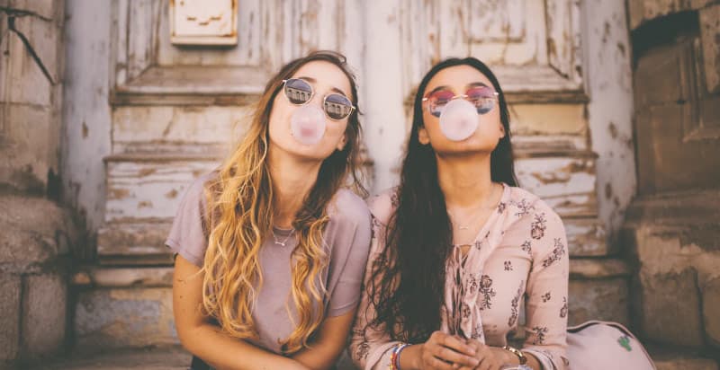 Two girls chewing sugar free gum