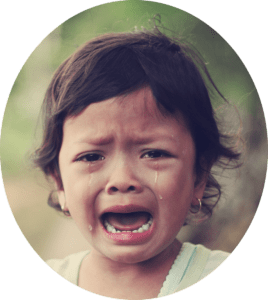 Closeup of a dark-haired child crying because she is afraid of the dentist